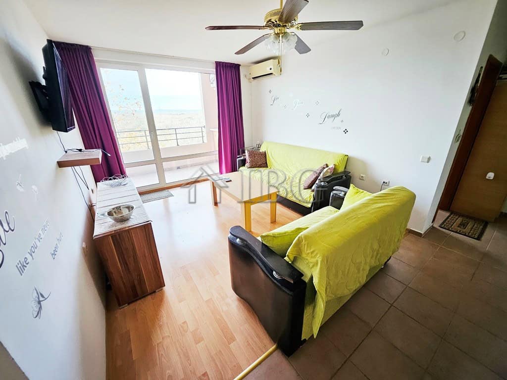 Bright living room with balcony view at Holiday Fort Golf Club.