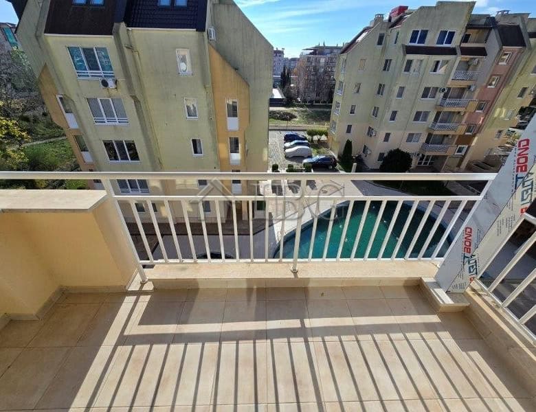 Bright balcony overlooking pool in Sunny Beach apartment complex.