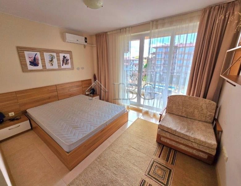 Cozy bedroom with pool view in LifeStyle 3, Ravda, featuring modern decor and balcony access.