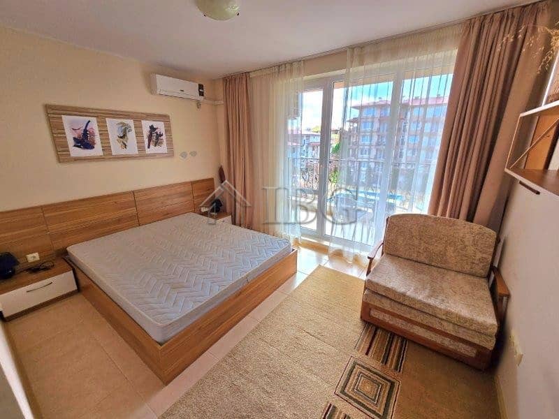Cozy bedroom with pool view in LifeStyle 3, Ravda, featuring modern decor and balcony access.