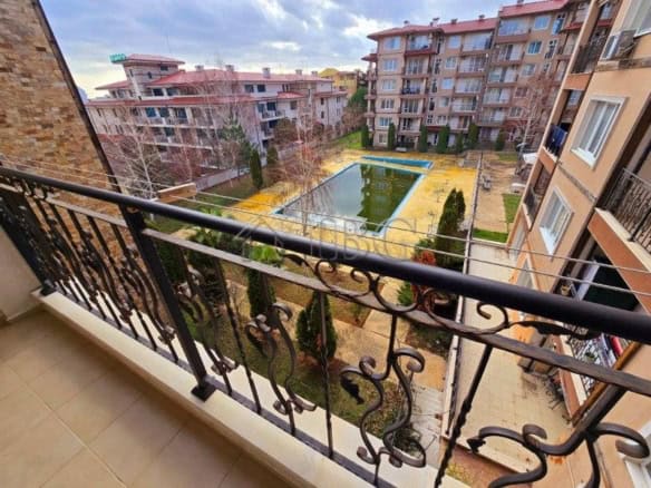 Balcony view of pool and courtyard in Ravda apartment complex.