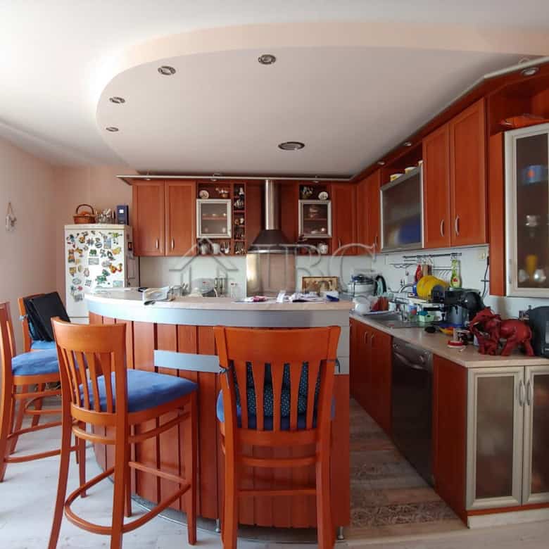 Bright and modern kitchen with ample space and wooden cabinetry.