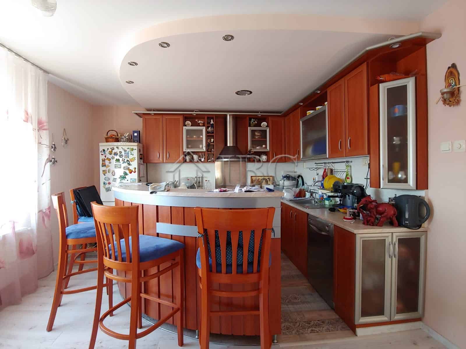 Bright and modern kitchen with ample space and wooden cabinetry.