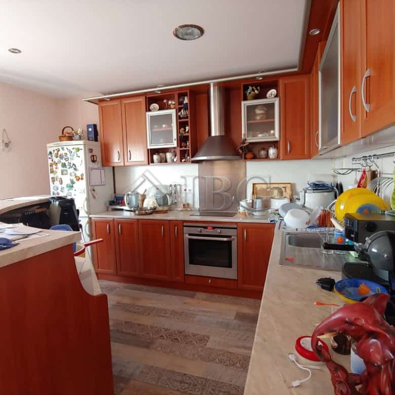 Bright and modern kitchen with wooden cabinets and essential appliances. Perfect for family cooking.