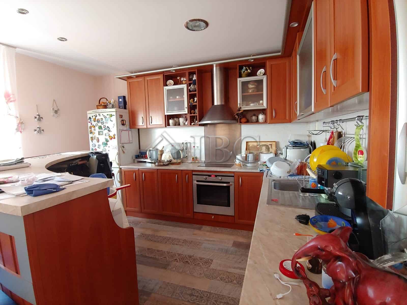 Bright and modern kitchen with wooden cabinets and essential appliances. Perfect for family cooking.