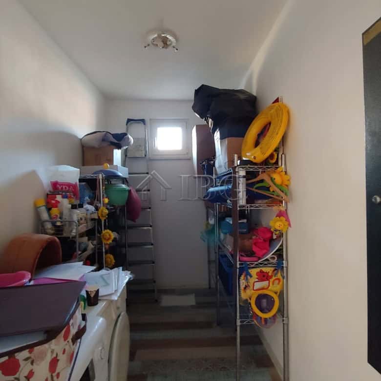 Bright interior view of a spacious house with storage shelves and household items.