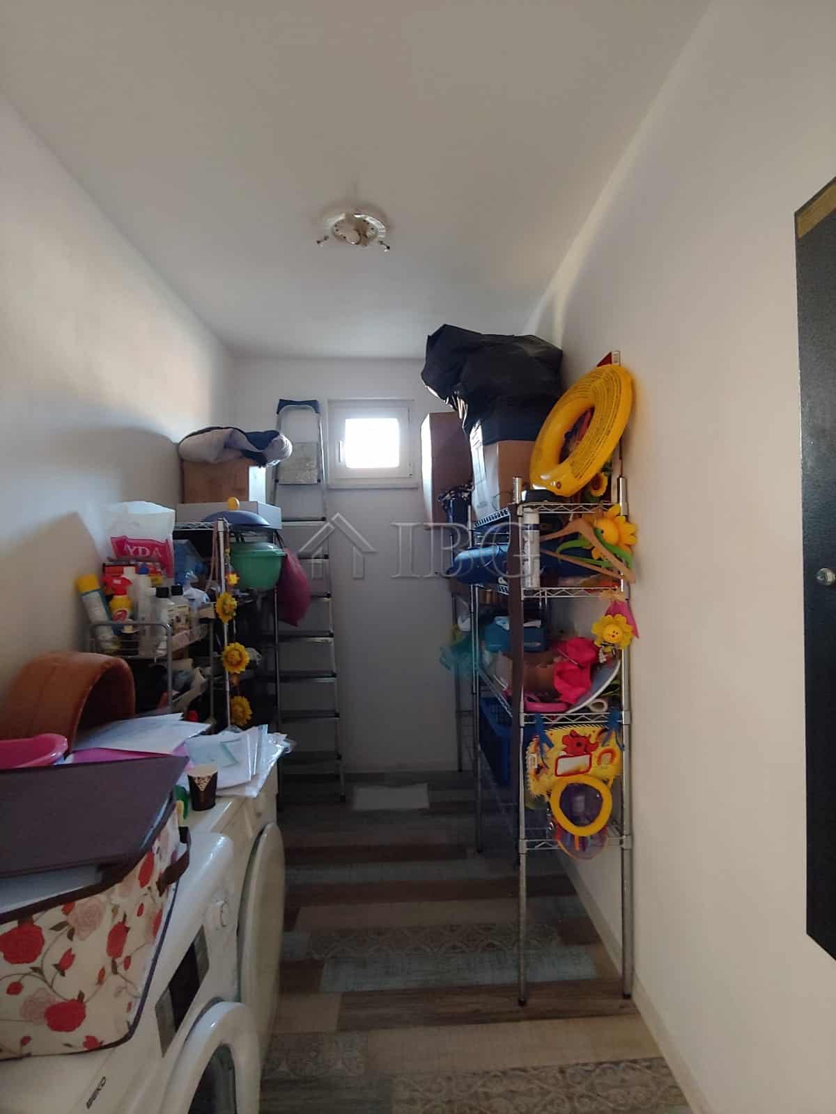 Bright interior view of a spacious house with storage shelves and household items.