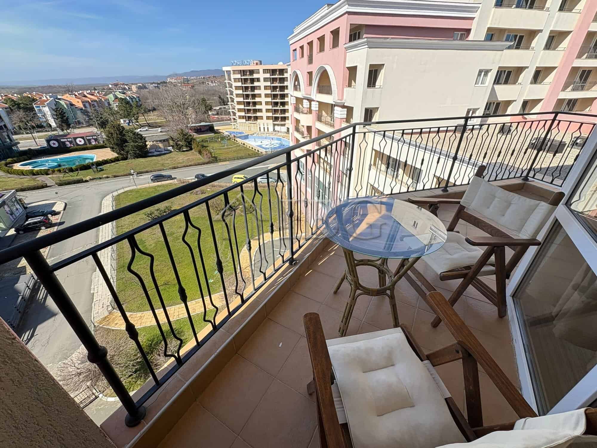 Balcony overlooking the sunny beach resort with outdoor seating and scenic ocean views. Perfect for.