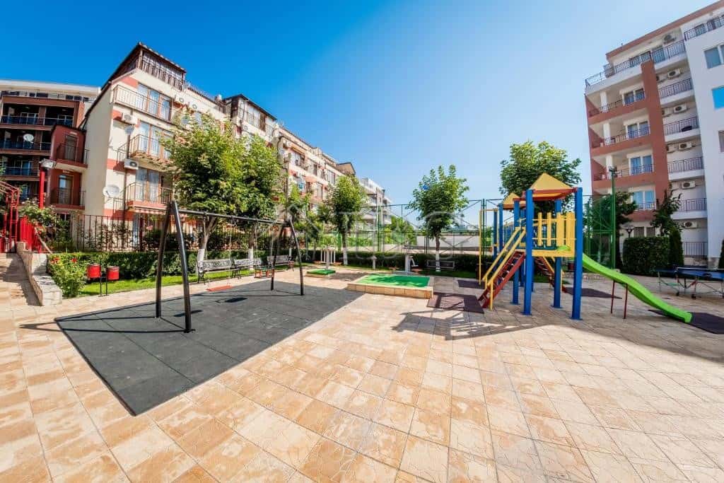 Spacious playground with swings and slides in a well-maintained residential area.