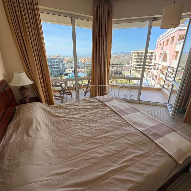 Apartment with bedroom, balcony, and city views at Majestic Beach Resort.