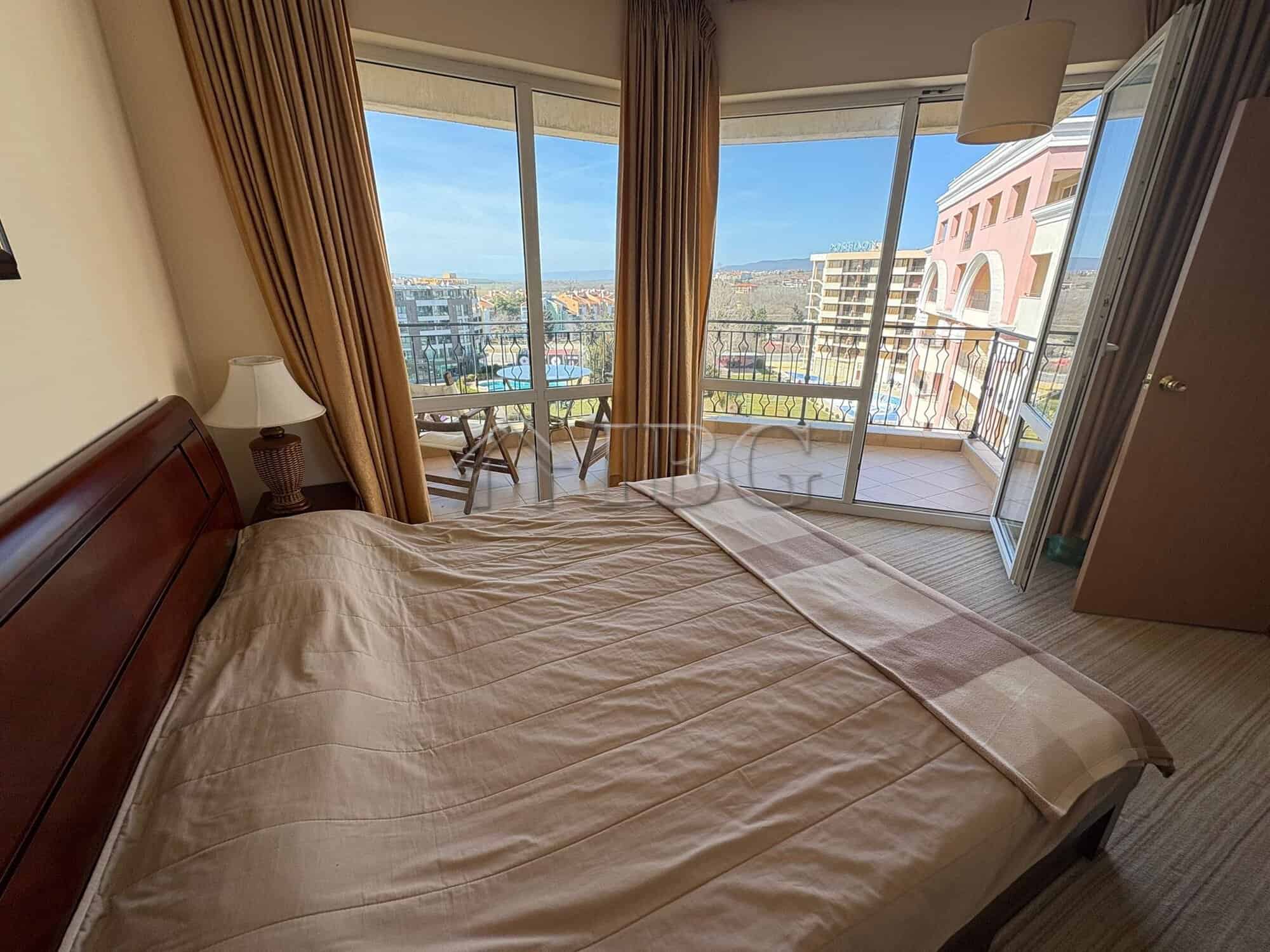 Apartment with bedroom, balcony, and city views at Majestic Beach Resort.