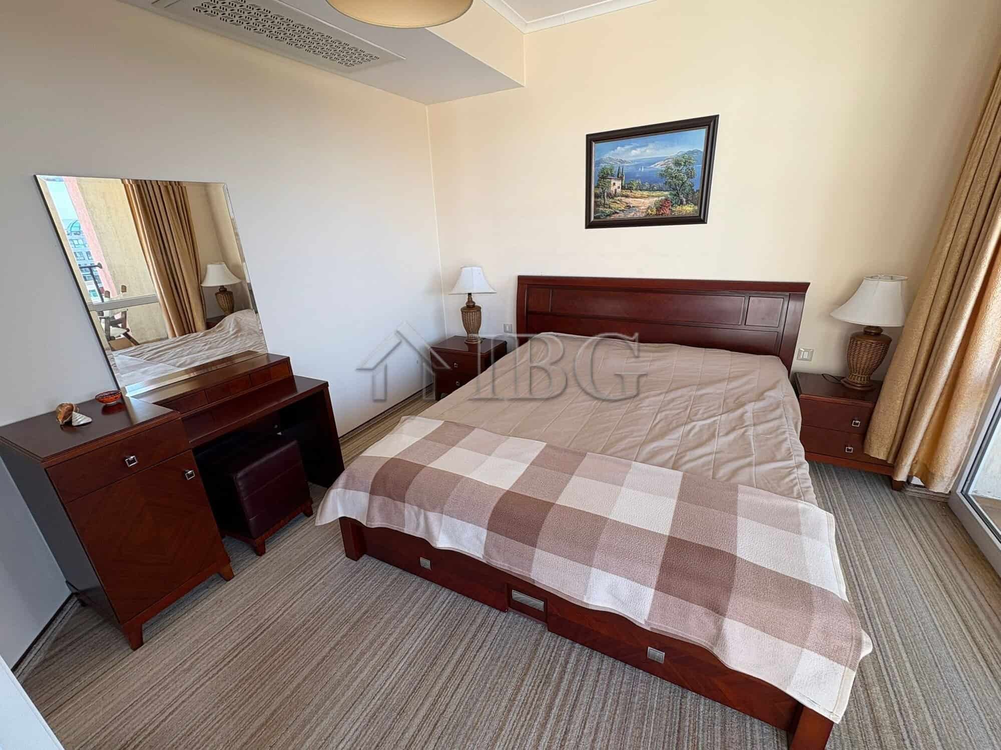 Spacious bedroom with modern furniture and balcony access at Sunny Beach. Perfect for relaxing holid.