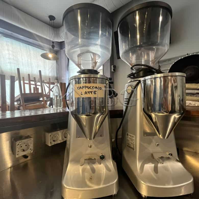 Commercial coffee grinders for fresh espresso preparation in a restaurant setting.