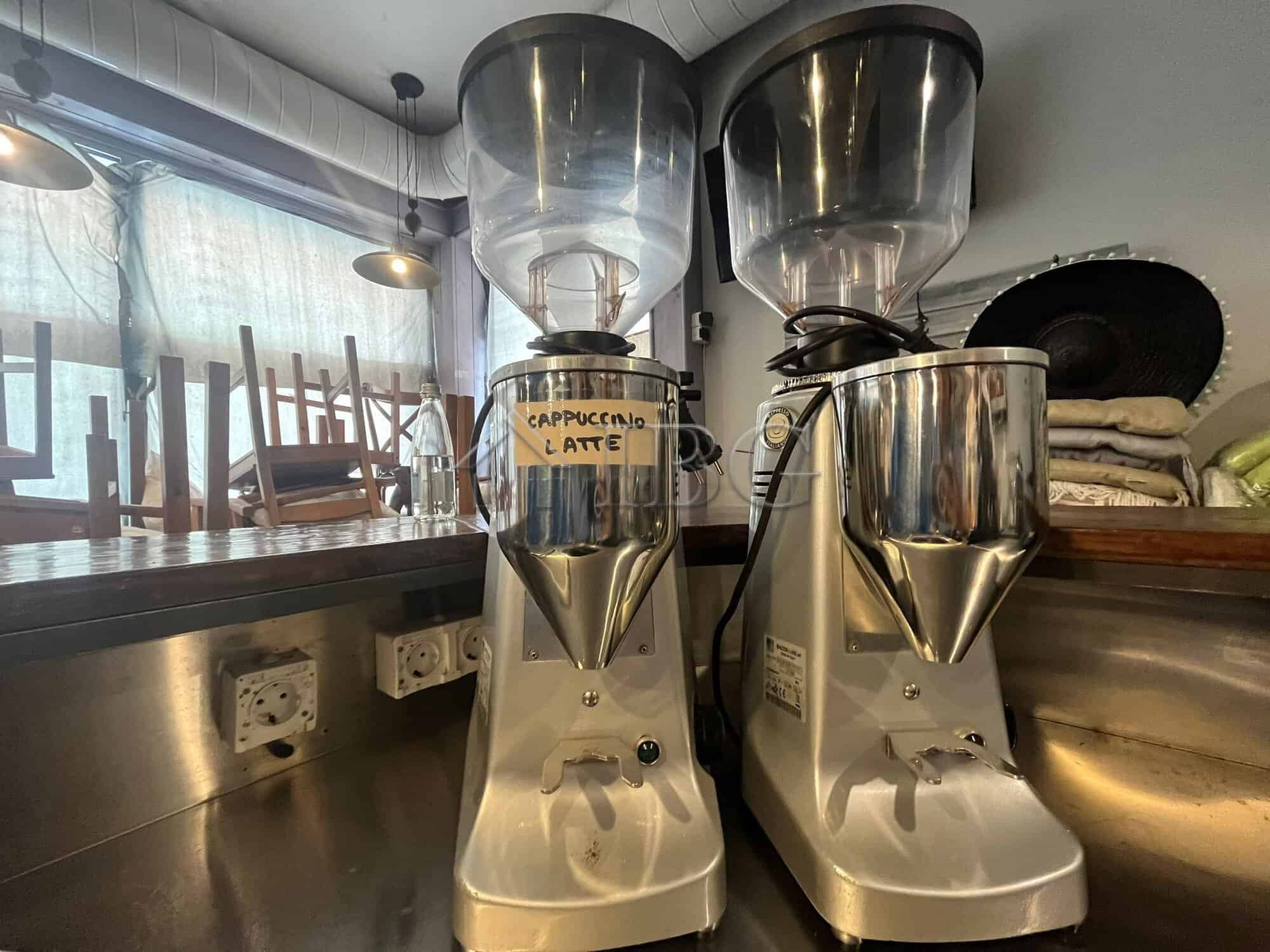 Commercial coffee grinders for fresh espresso preparation in a restaurant setting.