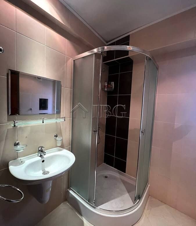 Compact studio bathroom with shower enclosure and modern fixtures.