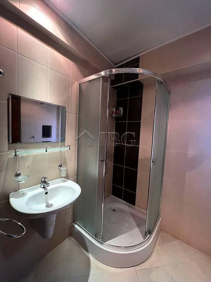 Compact studio bathroom with shower enclosure and modern fixtures.