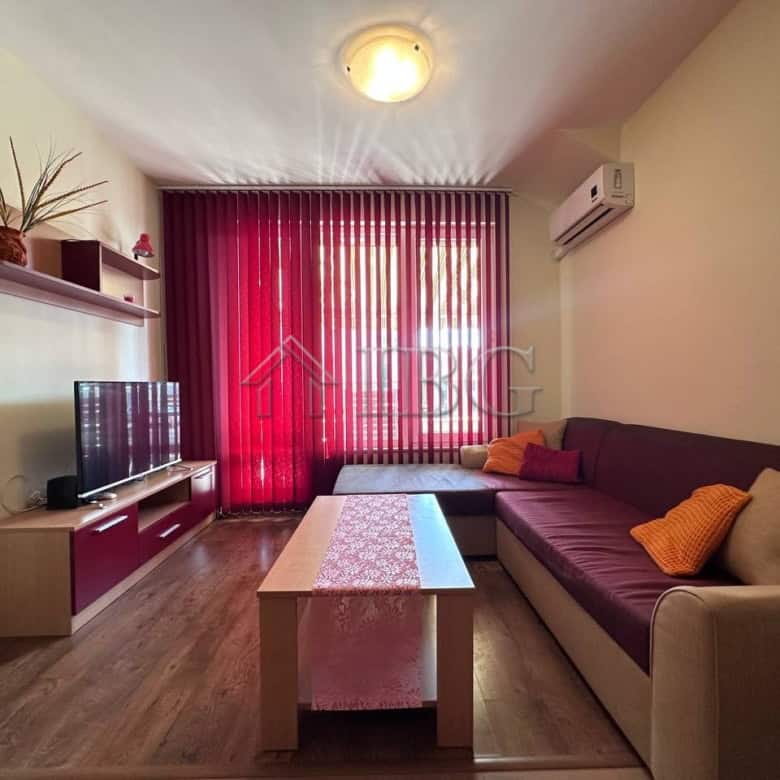 Cozy 1-bedroom apartment in Ravda with living room, TV, and colorful cushions.