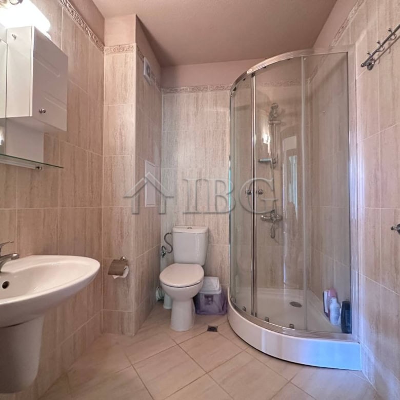 Bright bathroom with shower enclosure in Ravda residential building.