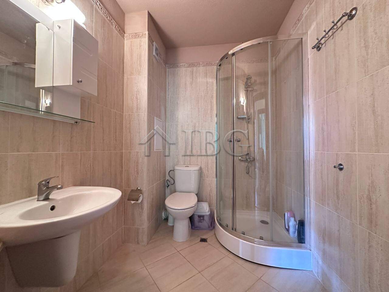 Bright bathroom with shower enclosure in Ravda residential building.