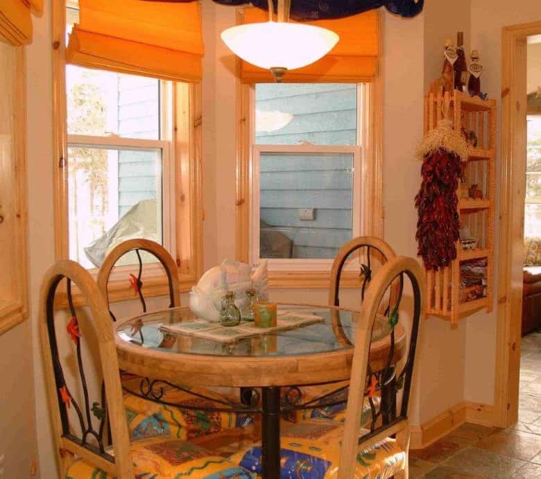 Ocean view dining nook with round table and four chairs in a charming seaside home.