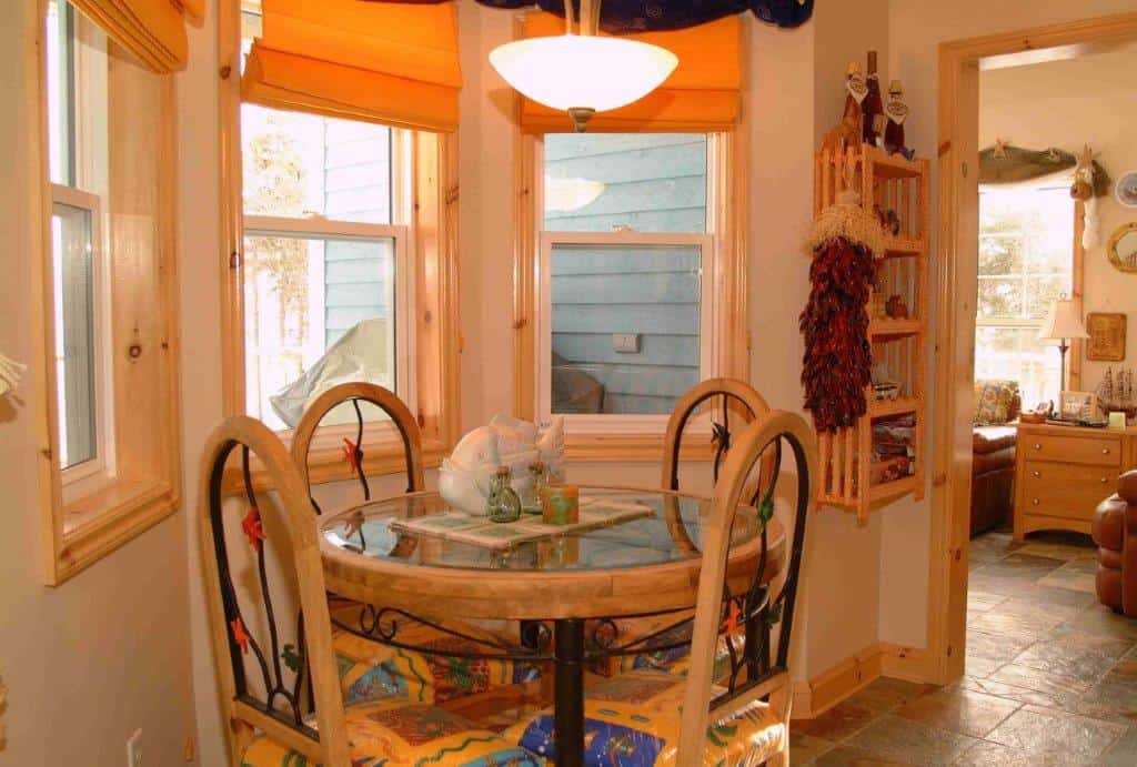 Ocean view dining nook with round table and four chairs in a charming seaside home.