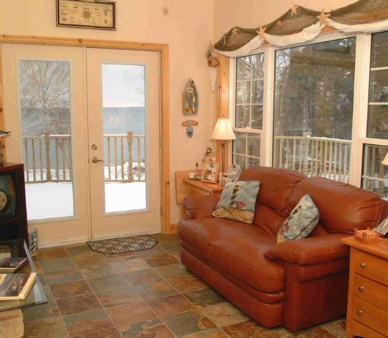 Interior view of a cozy living room with large windows overlooking the ocean in Nova Scotia.