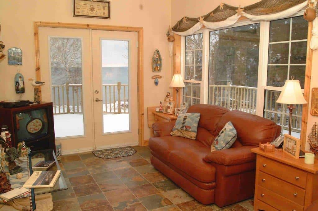 Interior view of a cozy living room with large windows overlooking the ocean in Nova Scotia.