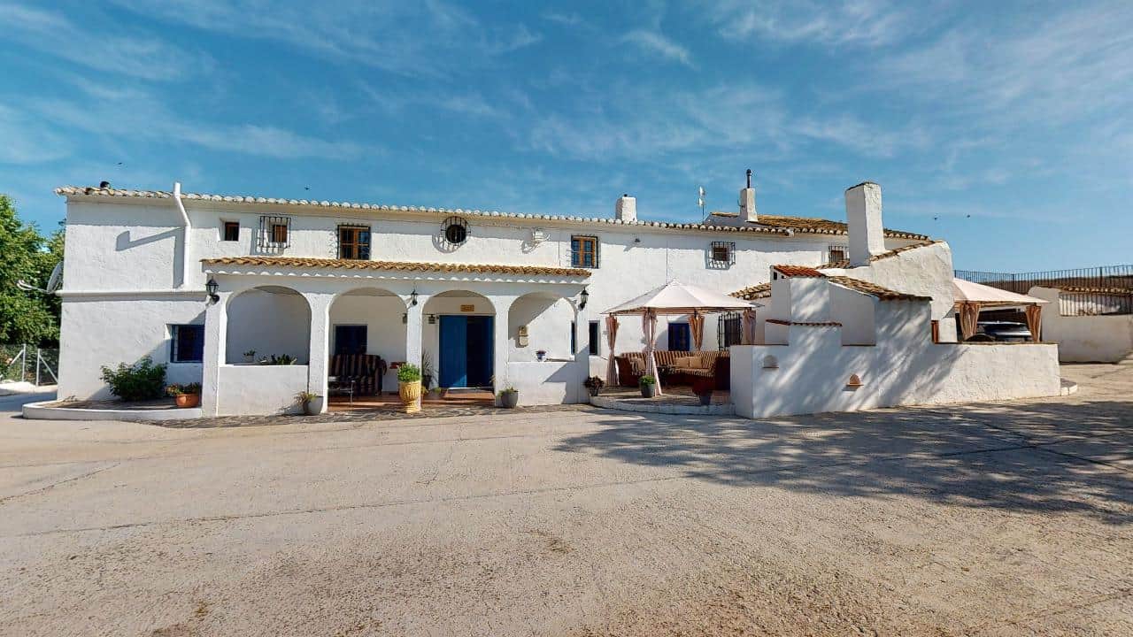 Charming boutique hotel in Caniles, Granada, Spain with whitewashed walls and outdoor seating area.