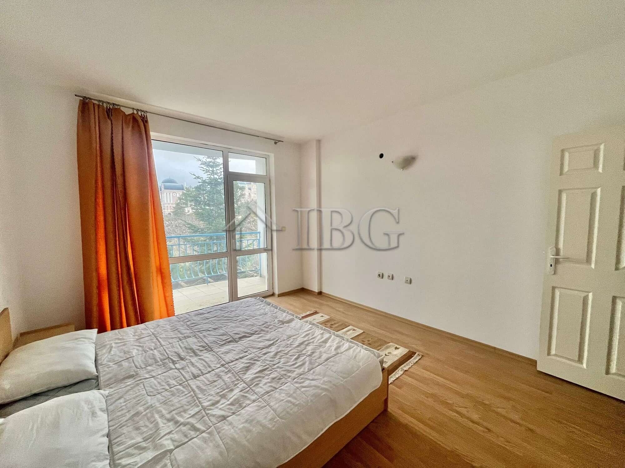 Bright bedroom with large window and balcony overlooking green area in Sveti Vlas.