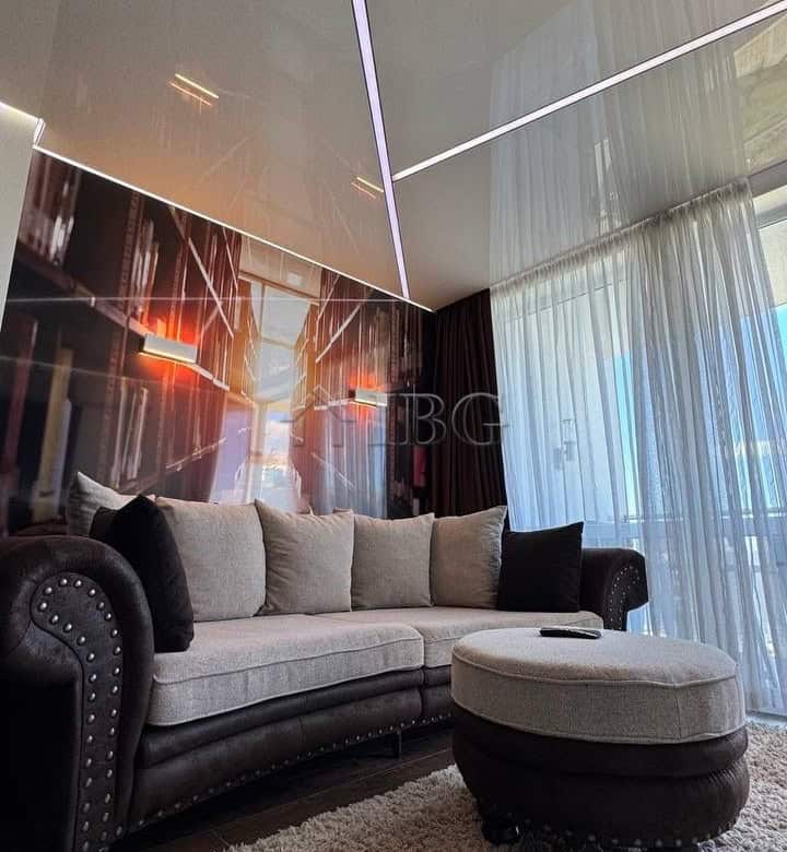 Modern living room with ceiling LED lights and large window overlooking the city.