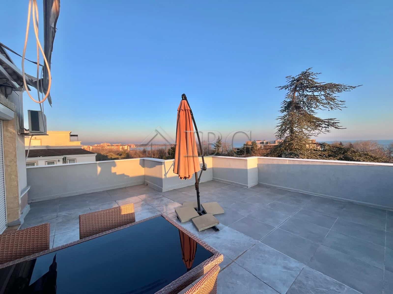 Terrace with sea view, umbrella, and outdoor furniture in Ravda apartment.