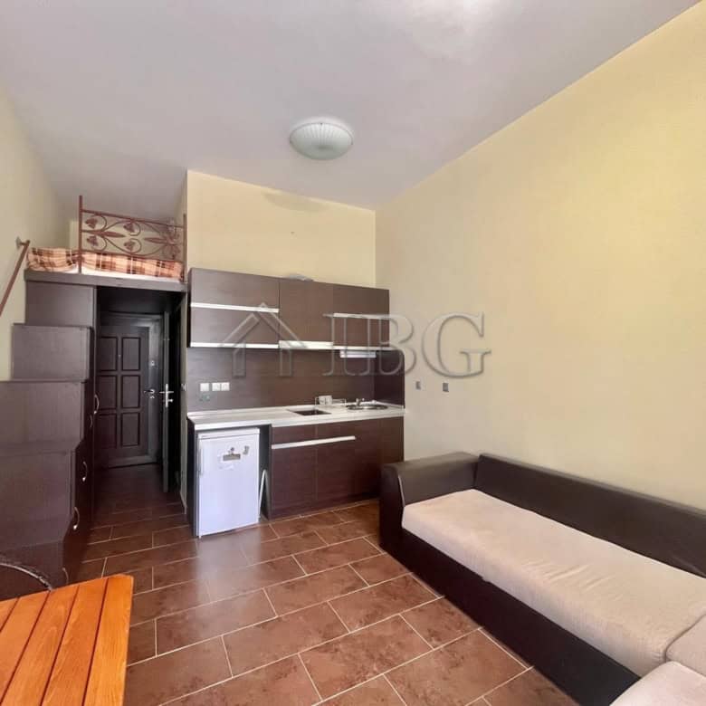 Cozy studio apartment with pool view in Odyssey, Nessebar, featuring a compact kitchen and seating a.