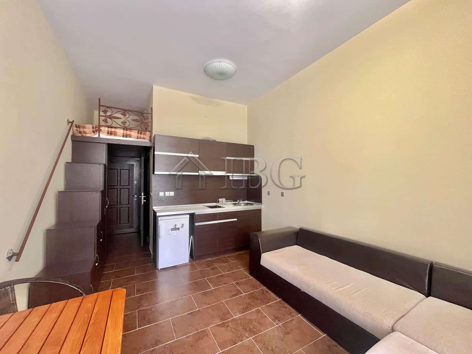 Cozy studio apartment with pool view in Odyssey, Nessebar, featuring a compact kitchen and seating a.