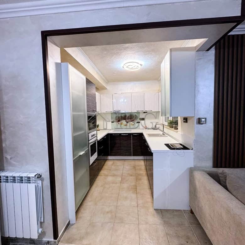 Modern kitchen with white and black cabinetry, sea views, and open layout in Victoria Hill property.
