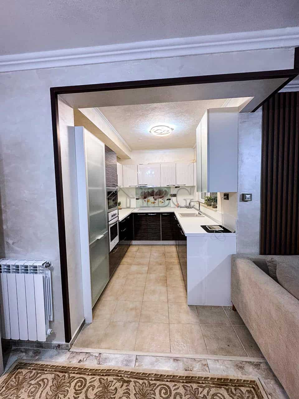 Modern kitchen with white and black cabinetry, sea views, and open layout in Victoria Hill property.
