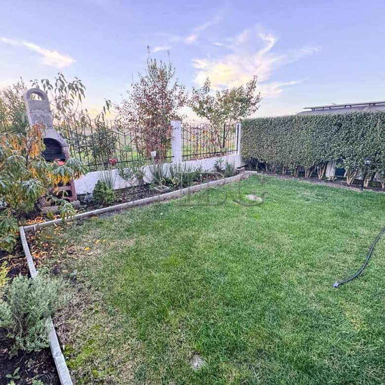 Beautiful backyard of a two-storey home with lush green lawn and sea views in Victoria Hill.