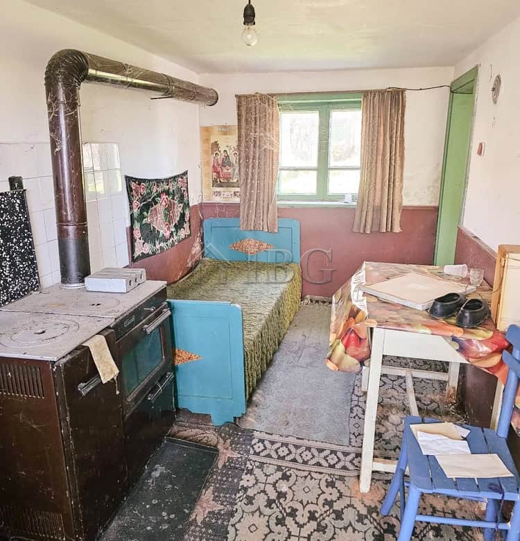 Interior of a house with potential for renovation, featuring a small kitchen and living area.
