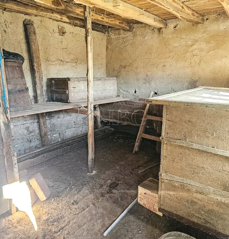 House with rustic interior, large open space, and wooden beams, ideal for renovation and development.