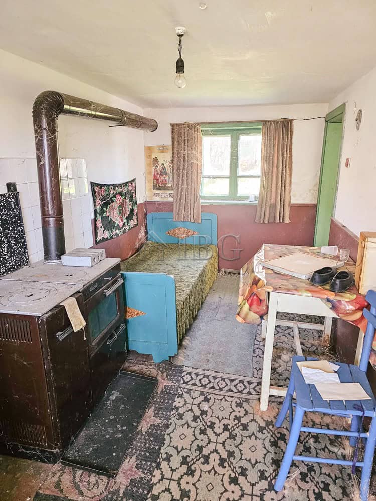 Interior of a house with potential for renovation, featuring a small kitchen and living area.