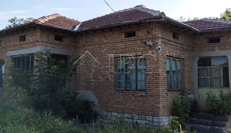 Brick house with renovated roof and garden in a peaceful village setting.
