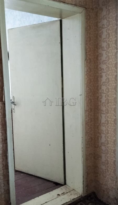 Door of a solid house with a renovated roof in a peaceful village setting.