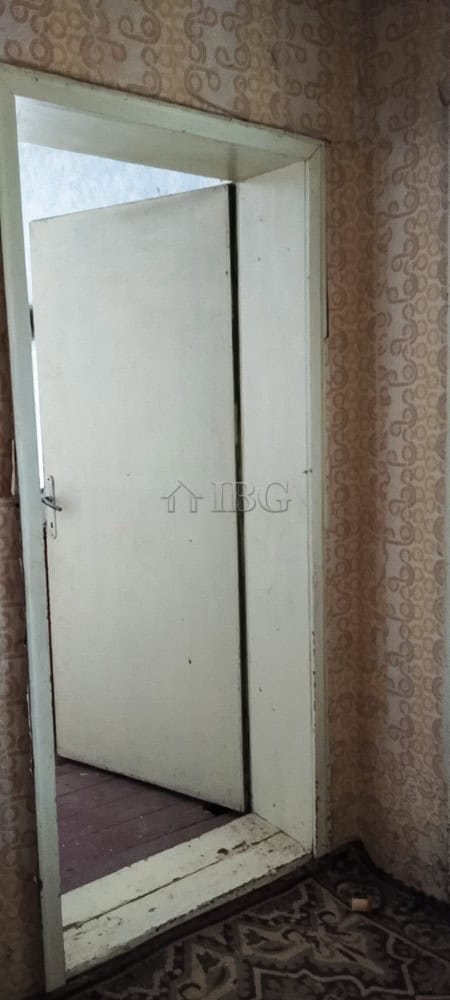 Door of a solid house with a renovated roof in a peaceful village setting.