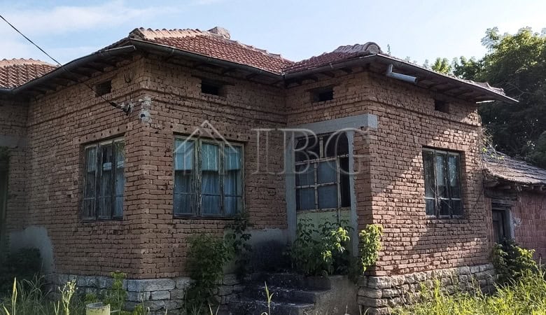 House with renovated roof and brick exterior in a peaceful village setting.
