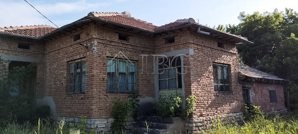House with renovated roof and brick exterior in a peaceful village setting.