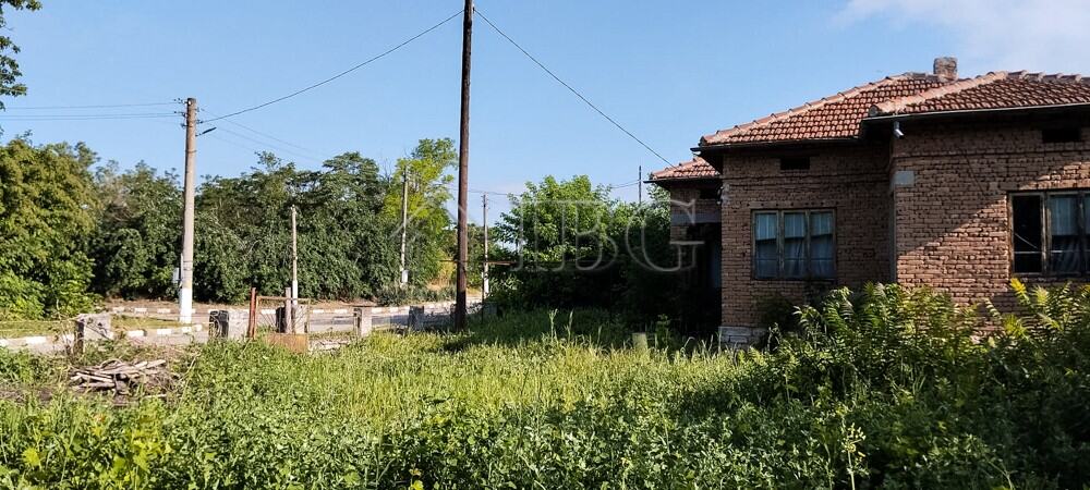 Traditional brick house with renovated roof and large garden in a peaceful village setting.
