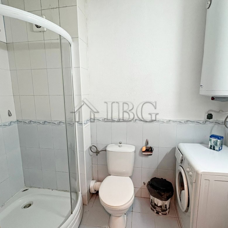 Cozy bathroom with shower in a sunny beach apartment near amenities.