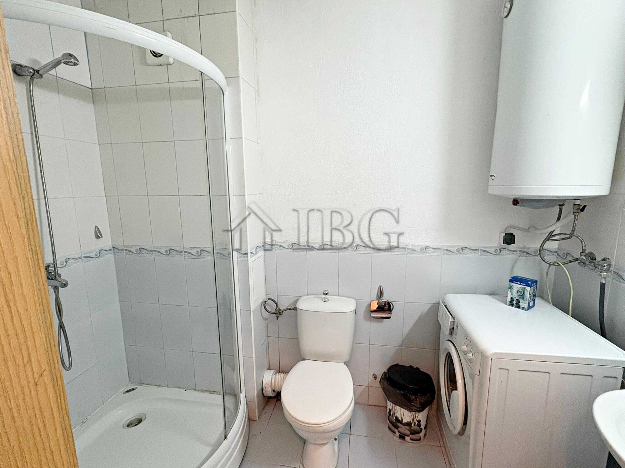 Cozy bathroom with shower in a sunny beach apartment near amenities.