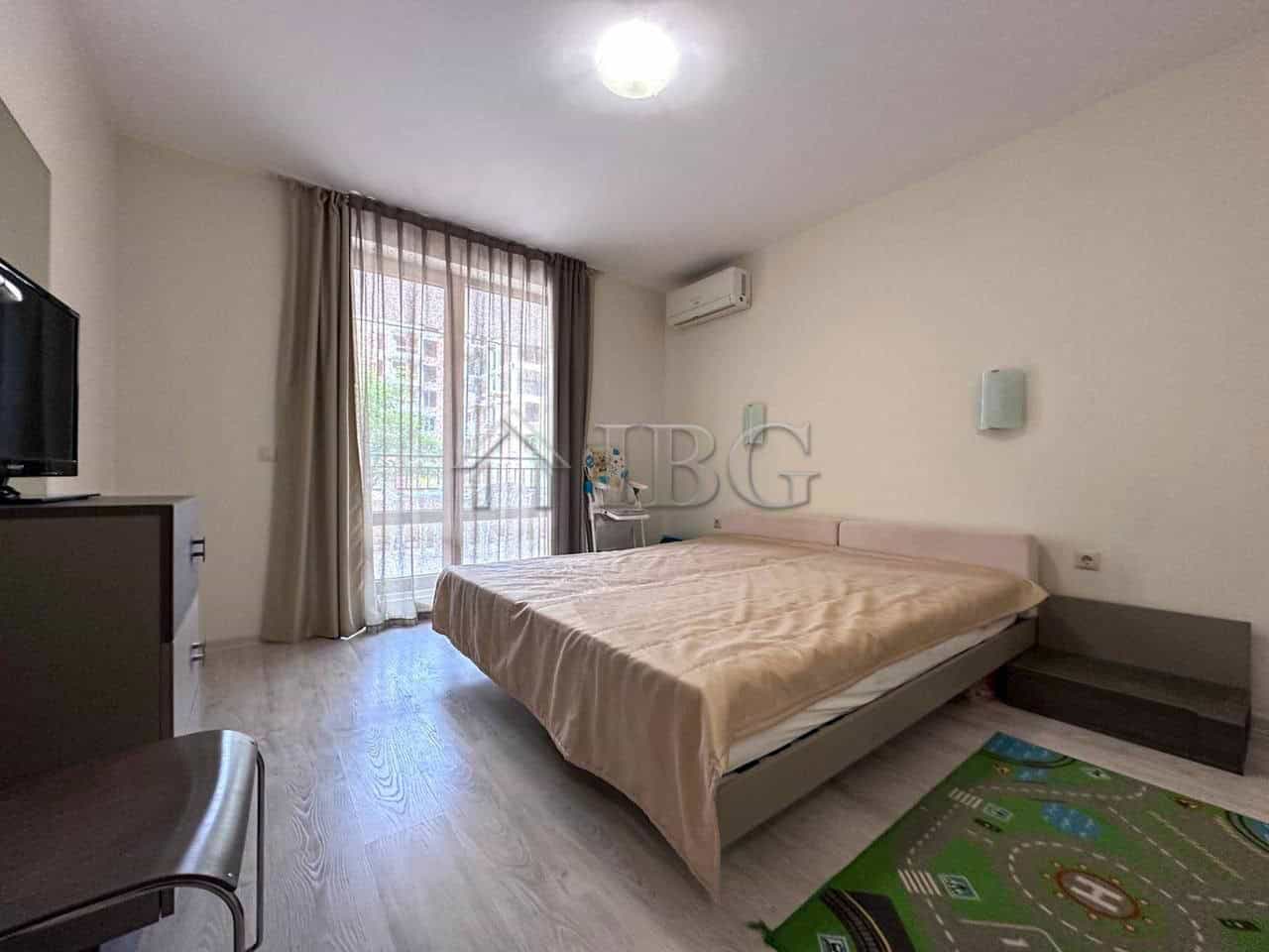 Modern One-Bedroom Apartment in Sveti Vlas Bright bedroom with large window and balcony access.