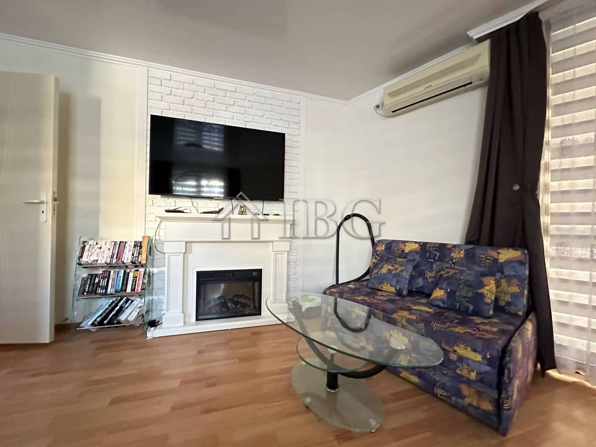 Modern living room with TV, fireplace, and sofa in Sveti Vlas apartment.
