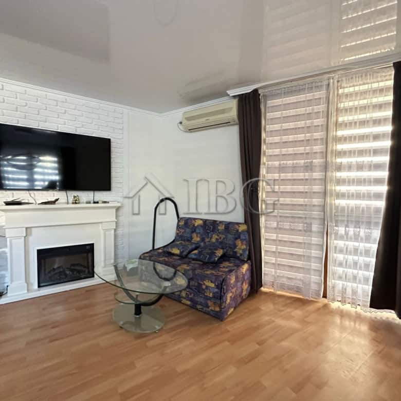 Bright living room with TV, sofa, and large windows in Sveti Vlas apartment.